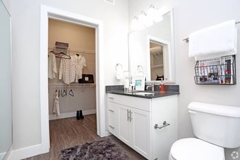 a bathroom with a vanity and a toilet and a closet at Century Baxter Avenue, Louisville, KY